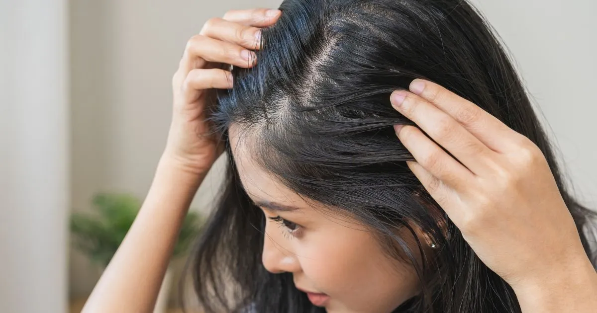 Young woman examining her scalp after HydraFacial Keravive Treatment in Beverly Hills, CA